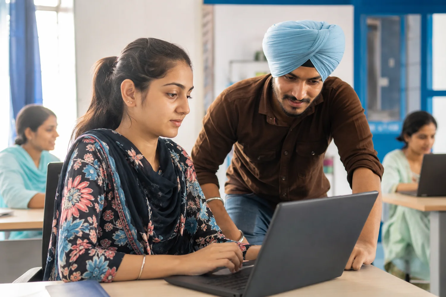 A young Punjabi learner working on digital skills with a mentor